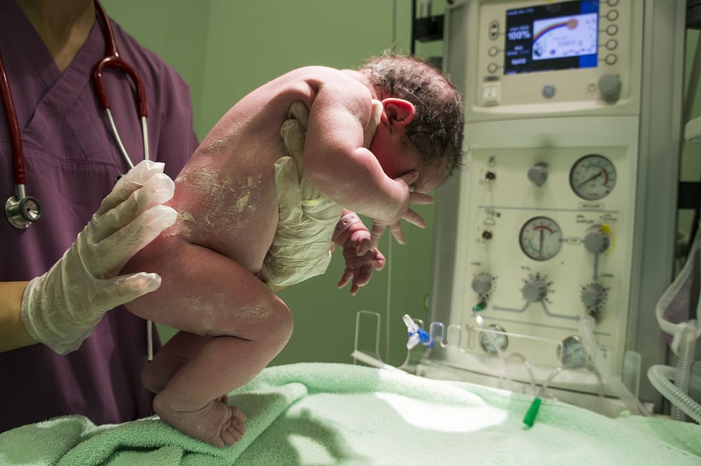 New born baby held by a nurse