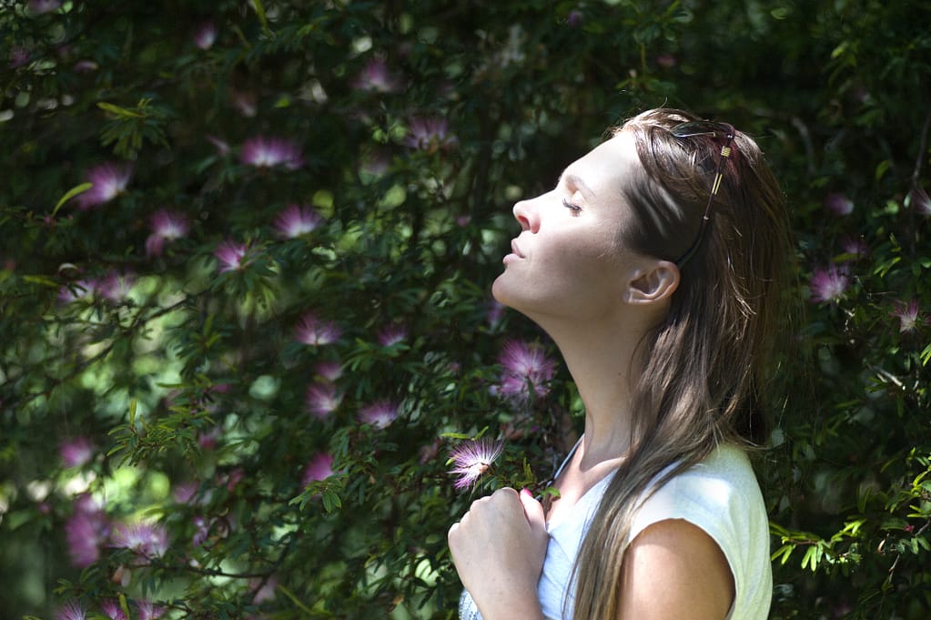 A woman taking a deep breath in nature