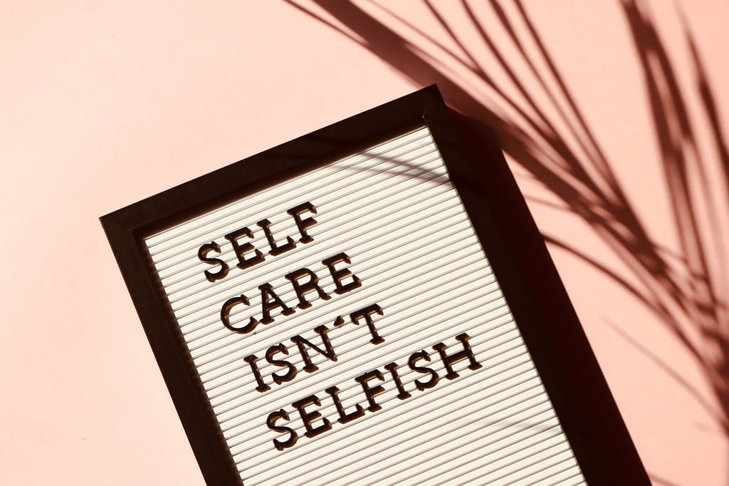 The words self care isn't selfish on a board