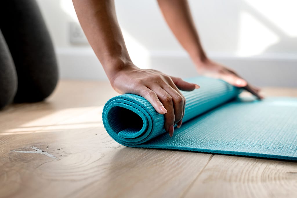 Person rolling up a yoga mat