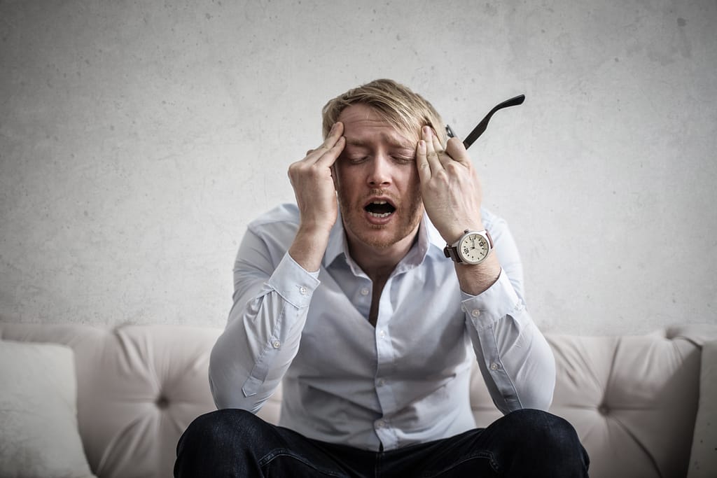 Photo of a man touching his head because he is anxious