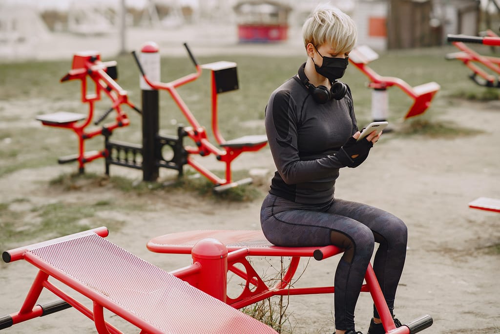 Woman in a mask exercising outdoors
