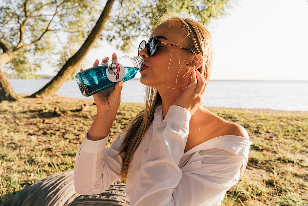 A woman drinking from a water bottle
