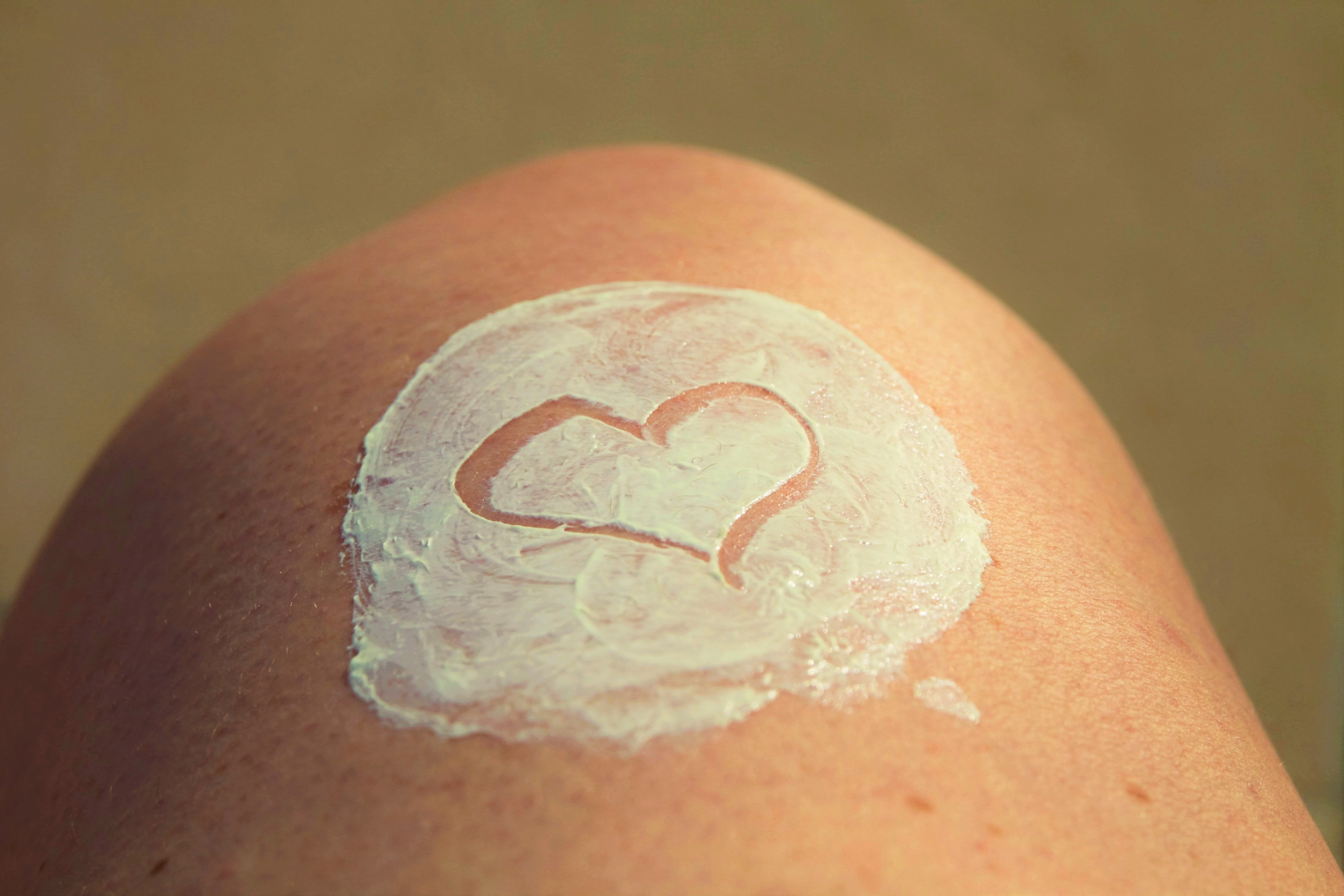 A heart drawn into cream applied on a thigh
