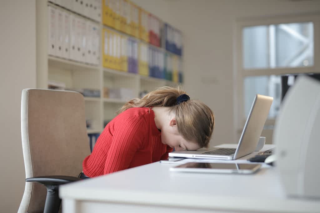 A woman with head down because of afternoon slump