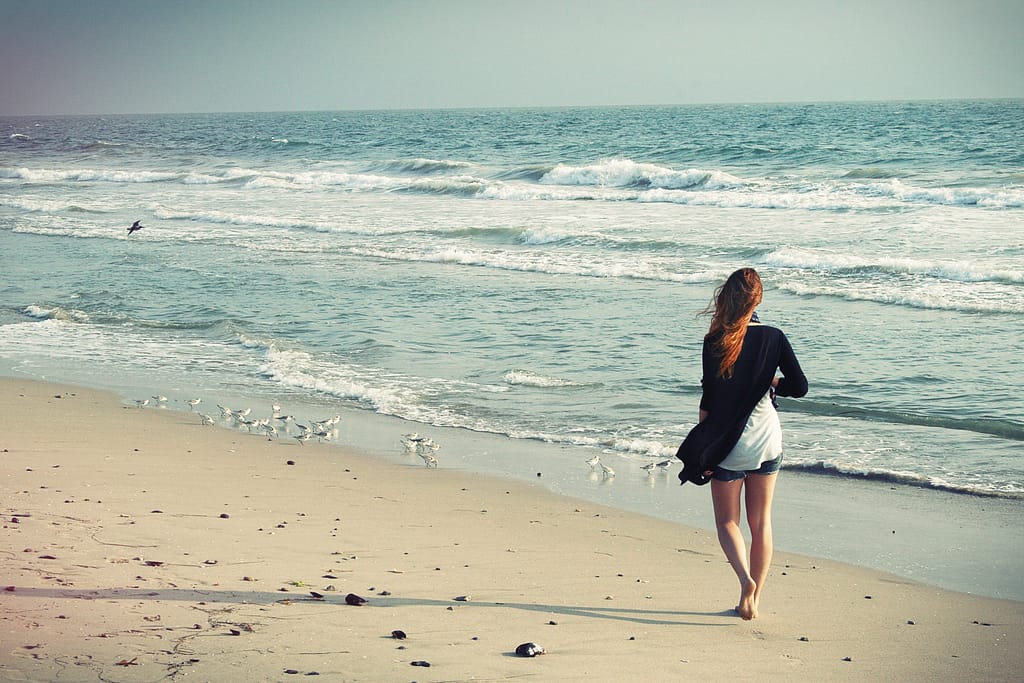 A woman walking alone on the beach