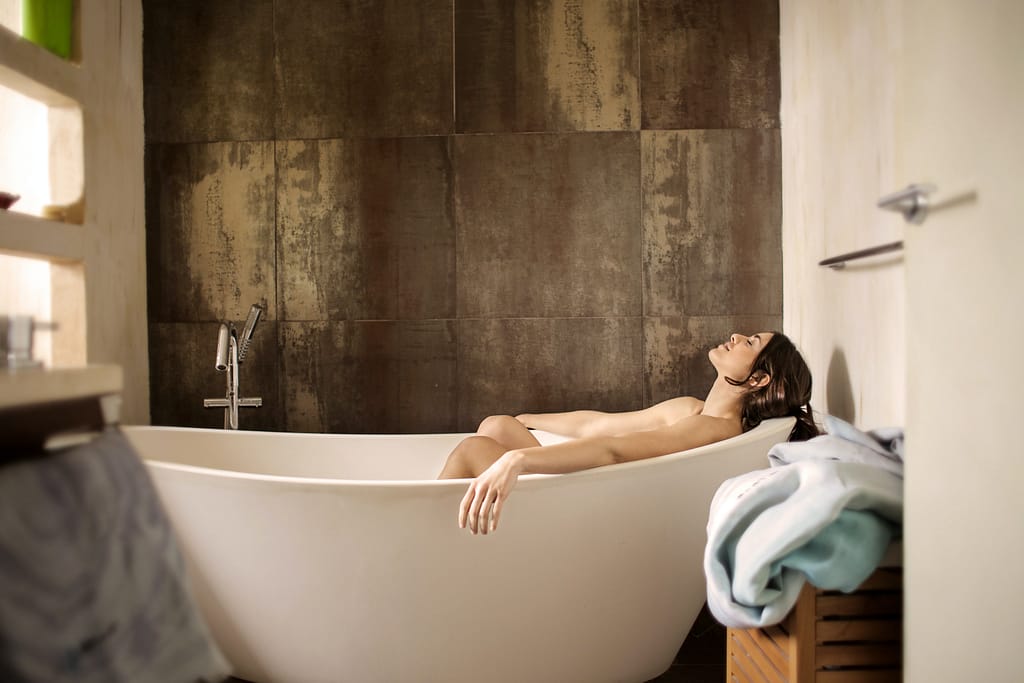 A woman lying down in a bathtub relaxing is a good way to clear your racing mind before sleep