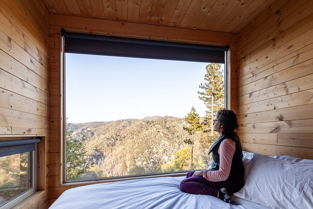 Getaway House Big Bear Pantea Rahimian looking outside while sitting on the bed