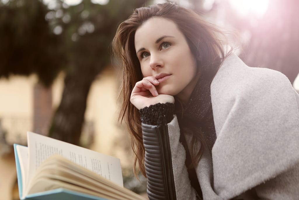 How to beat anxiety by changing your thoughts-a woman in deep thought while holding a book