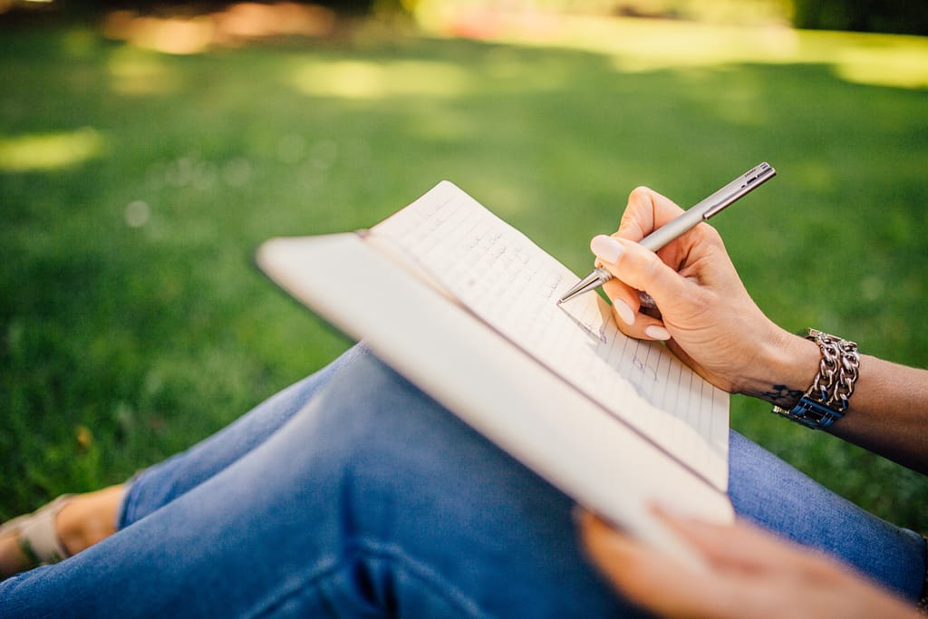 A woman using a journal to write her emotions to improve her mental health