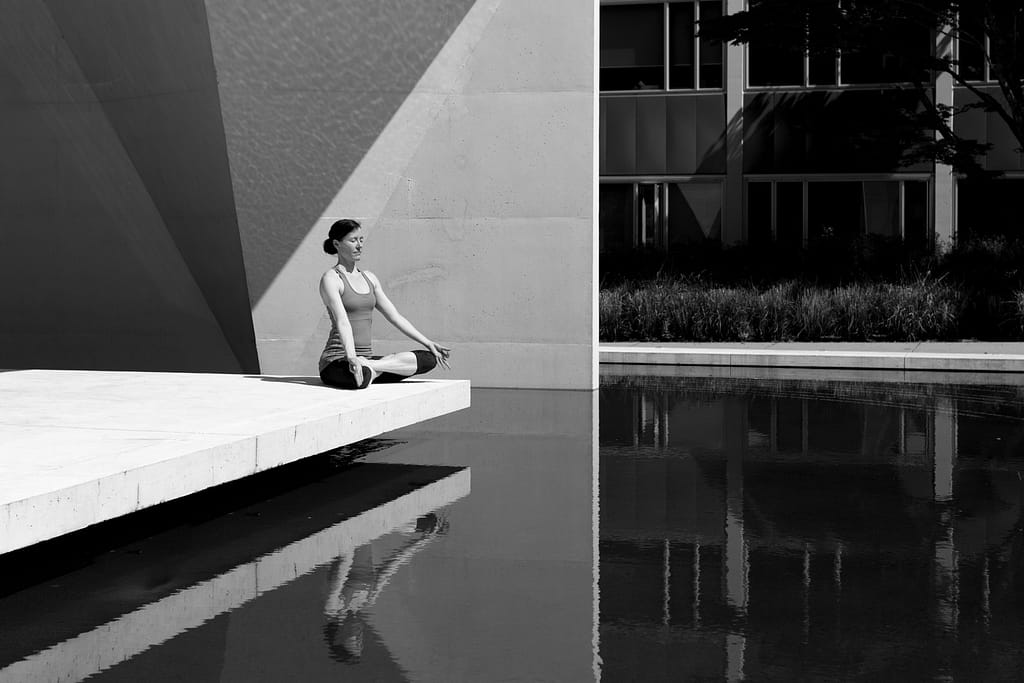A woman meditating by a pool