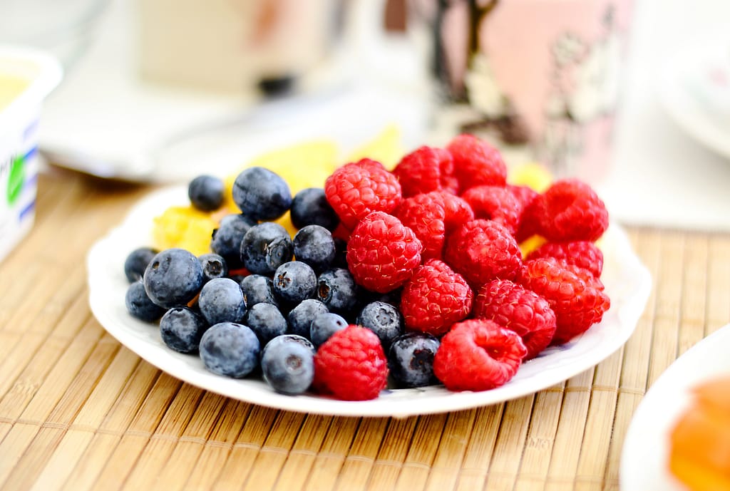 A plate with blueberries and raspberries