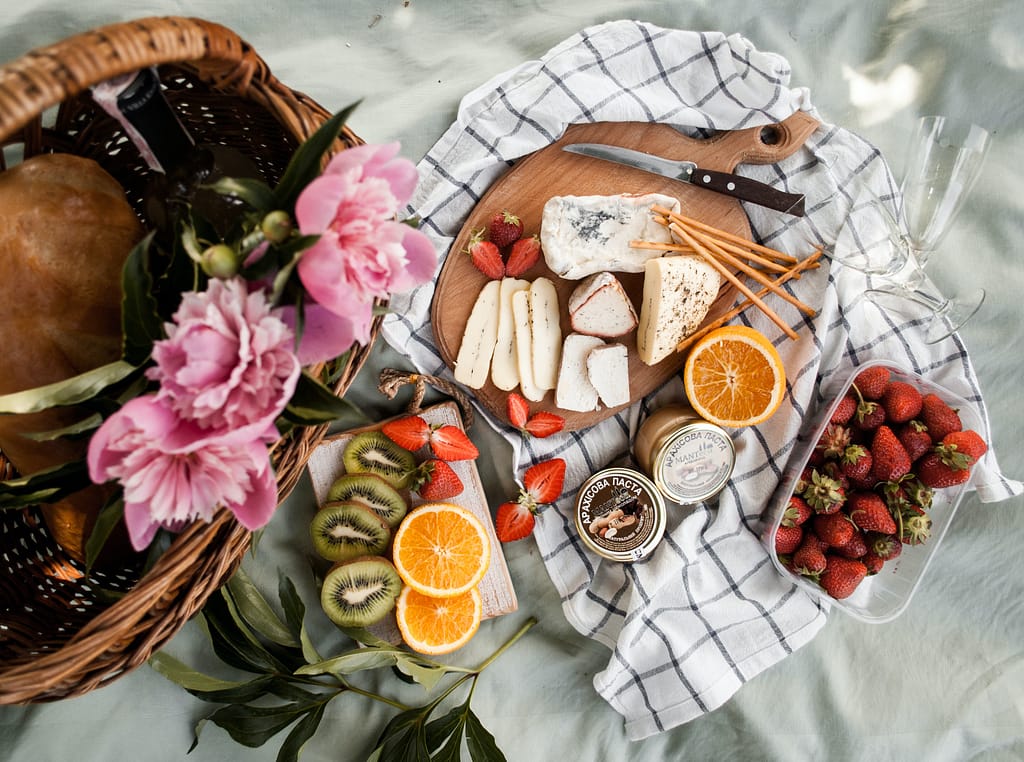 Variety of fruits and cheese on a picnic blanket