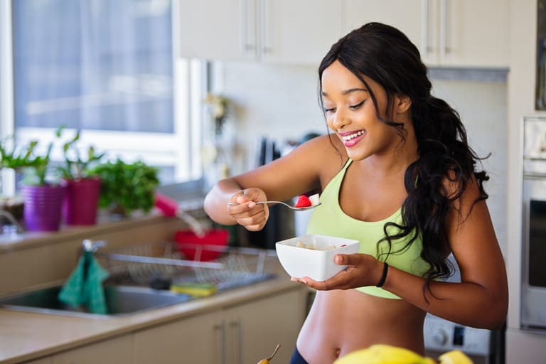 A woman starting her morning daily healthy habits by eating a nutritious bowl of fruits