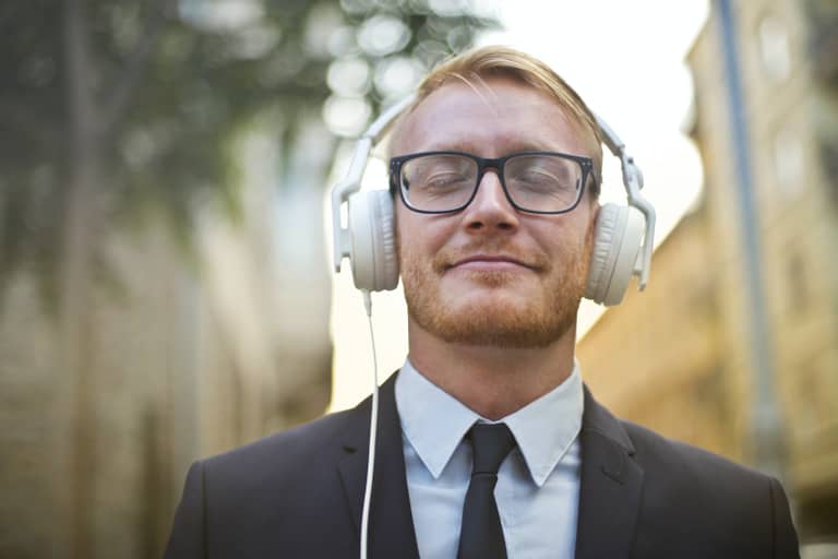 How to do meditation at work: a man with his eyes closed listening to headphones